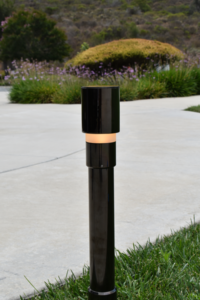 The LBD-H Hermosa bollard gracefully lines the border of a concrete path in a garden with flowering and grassy beds in Carlsbad, California. Photo by Laikyn Olson.